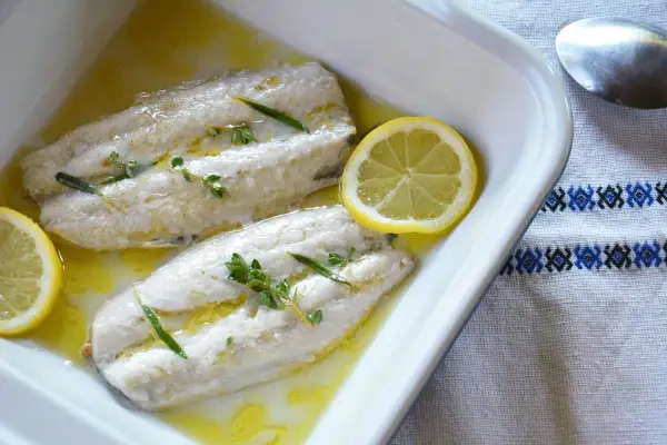 Deux filets de maquereau au four, nappés d'une sauce dorée, ornés de thym et de rondelles de citron. Un plat simple et savoureux.