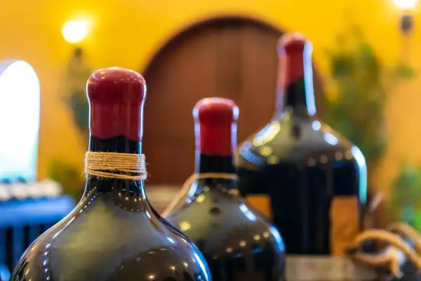 Trois bouteilles de vin, dont une en magnum litres, avec des bouchons rouges et une ficelle autour du col.