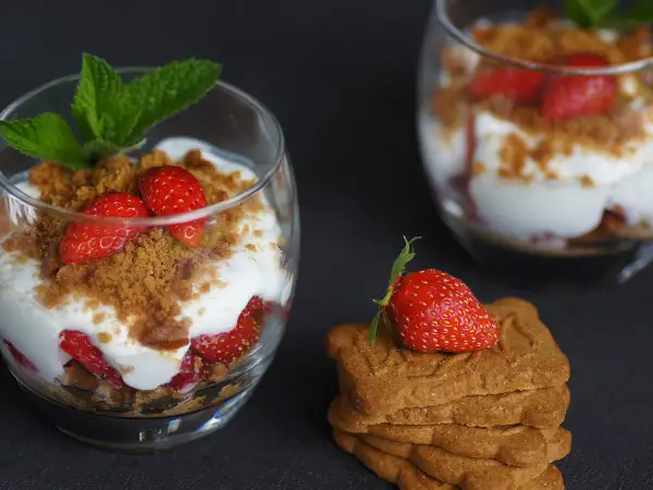Délicieux tiramisu fraises spéculoos, superposé dans un verre avec des fraises fraîches, de la crème et des miettes de spéculoos.