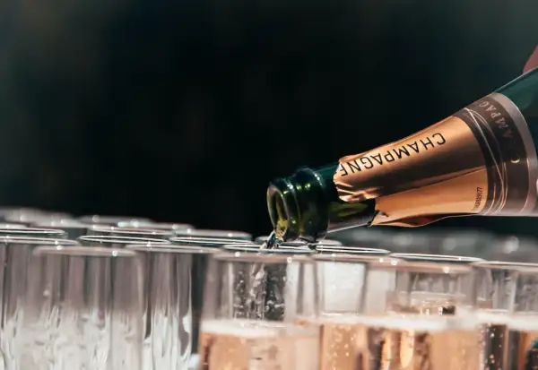 Champagne versé dans des flûtes, la contenance d'un jéroboam promet une belle fête.