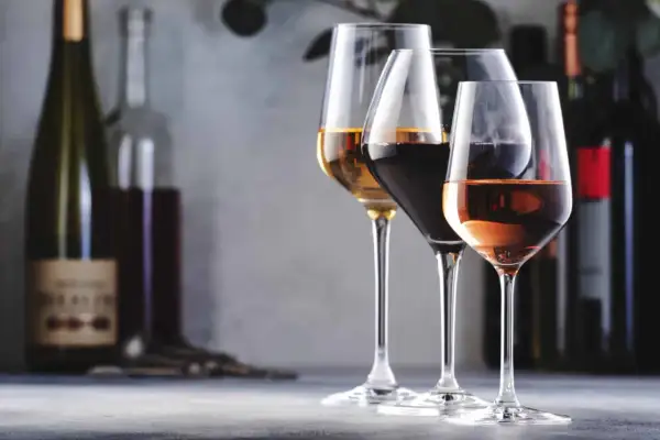 Trois verres de vin, un blanc, un rouge et un rosé, se tiennent sur une table. L'un d'eux, le blanc, semble avoir un goût de vin oxydé.