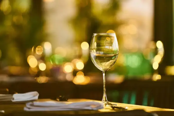 Verre de vin blanc sur une table, ambiance feutrée. La durée conservation vin blanc fermé est une question clé pour apprécier pleinement ses arômes.