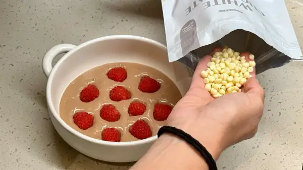 Préparation d'un bowl cake aux framboises, ajout de pépites de chocolat blanc.